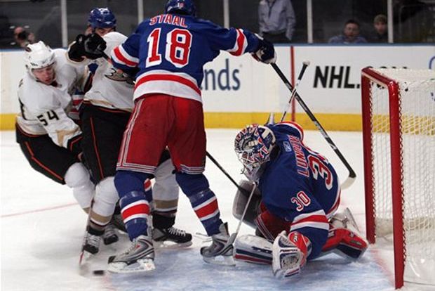 Photograph of the Ducks' Bobby Ryan shooting the puck past the Rangers' Marc Staal and Henrik Lundqvist by Ed Betz